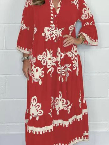 Red dress with white patterns worn by a person against a white brick wall.