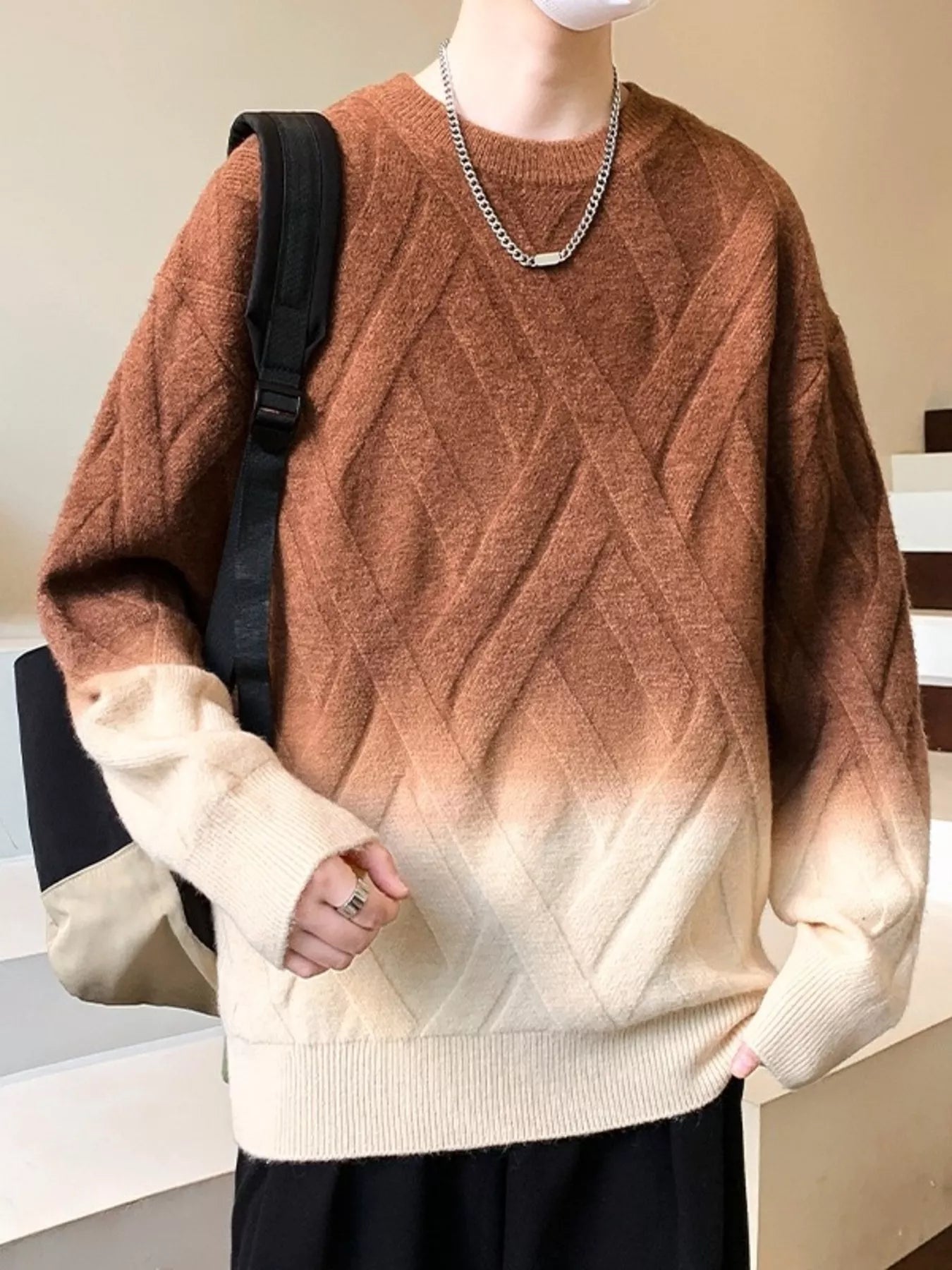 Person wearing a brown and beige gradient sweater with a black backpack.