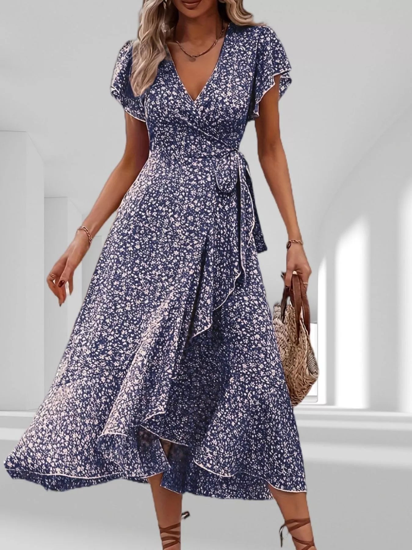 Woman wearing a blue floral dress in a bright room.