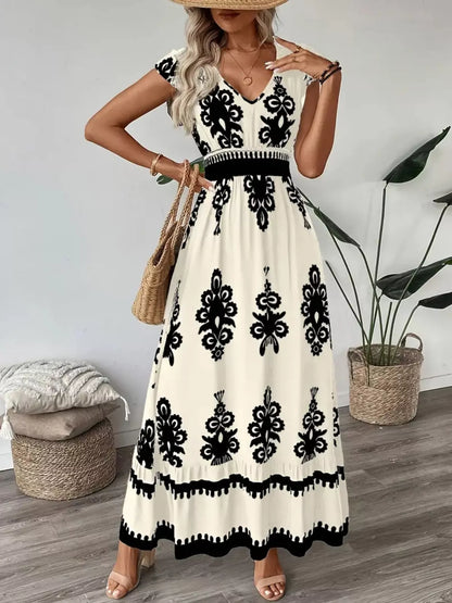 Woman wearing a white dress with black patterns, standing indoors.