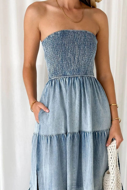 Woman wearing a strapless denim dress against a white background