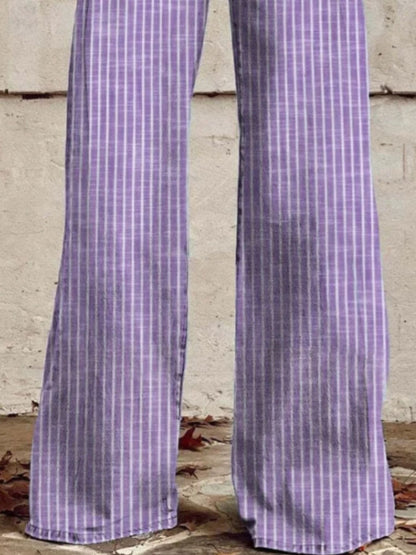 Purple checkered pants worn by a person against a concrete wall.