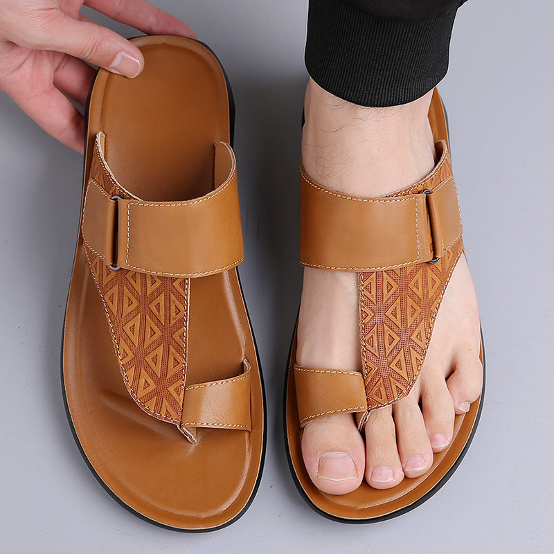 Brown sandals with geometric pattern worn by a person on a gray background