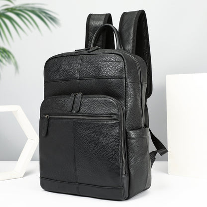 Black leather backpack on a white surface with a light gray background