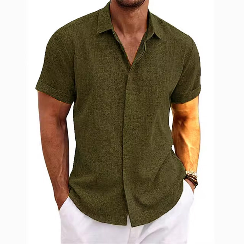 Man wearing a green short-sleeve button-up shirt and white pants on a white background