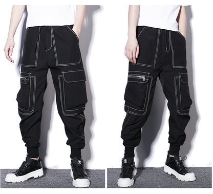 Black cargo pants with white stitching worn by a person on a white background