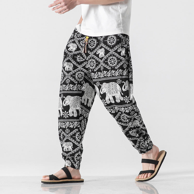 Person wearing black and white patterned pants with elephant design on a white background