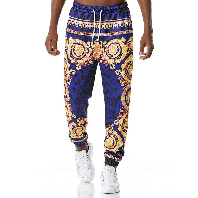 Blue and gold patterned jogger pants worn by a person on a white background