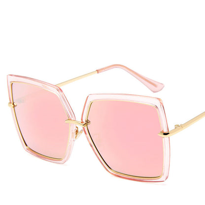 Sunglasses with pink lenses and gold frames on a white background