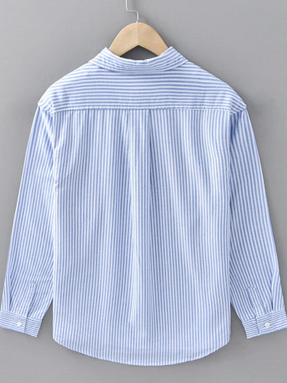 Blue and white striped shirt on a wooden hanger against a gray background