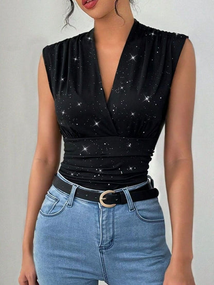 Black star-patterned top worn by a person with blue jeans on a plain background