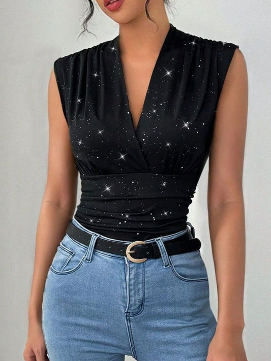 Black star-patterned top worn by a person with blue jeans on a plain background