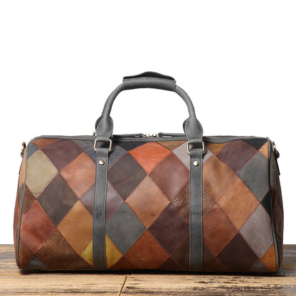 Patchwork leather duffel bag on a wooden surface with a white background