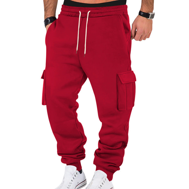 Red cargo jogger pants worn by a person on a white background