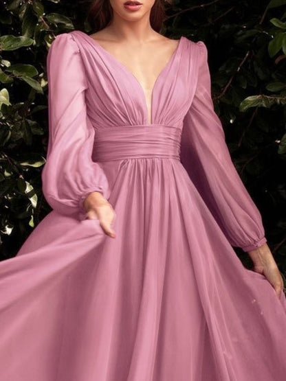 Pink evening gown with long sleeves against a dark background