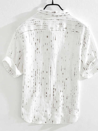 White shirt with black pattern on a hanger against a white background