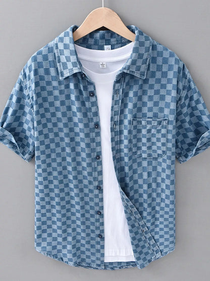 Blue checkered shirt on a hanger against a gray background