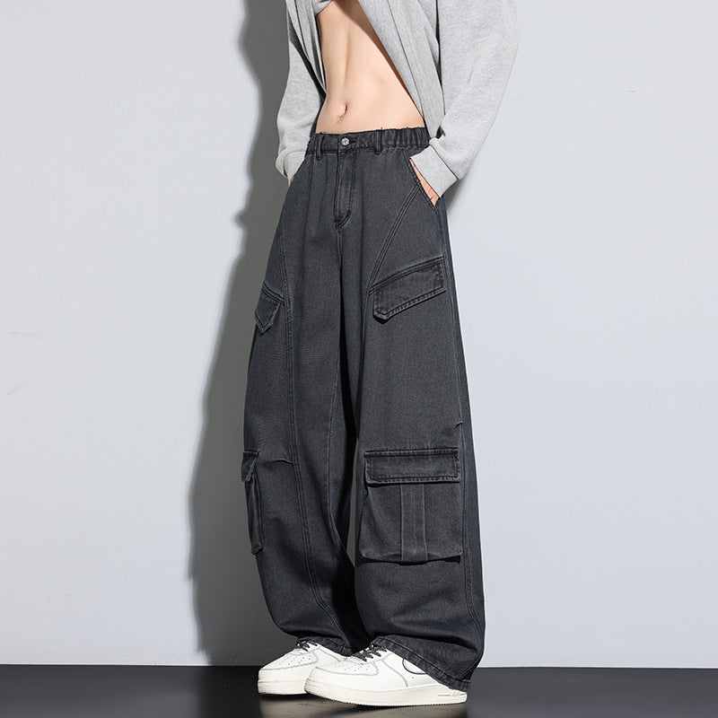 Person wearing black cargo pants with multiple pockets on a plain background