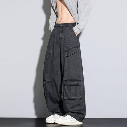 Person wearing black cargo pants with multiple pockets on a plain background