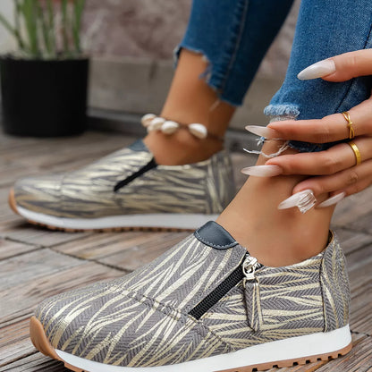Person wearing patterned slip-on shoes with a blurred background