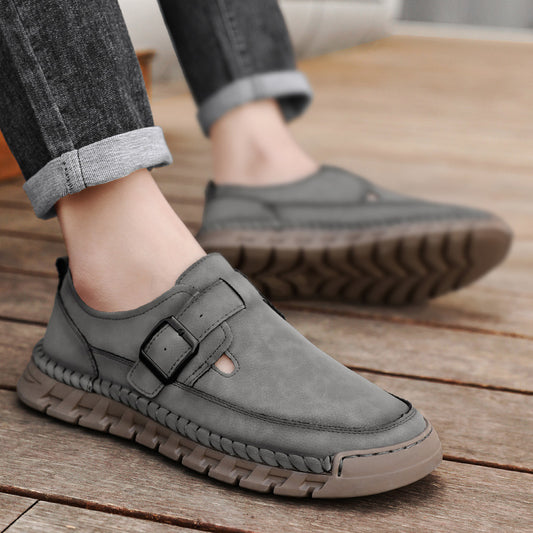 Gray casual shoes with a buckle on a wooden floor