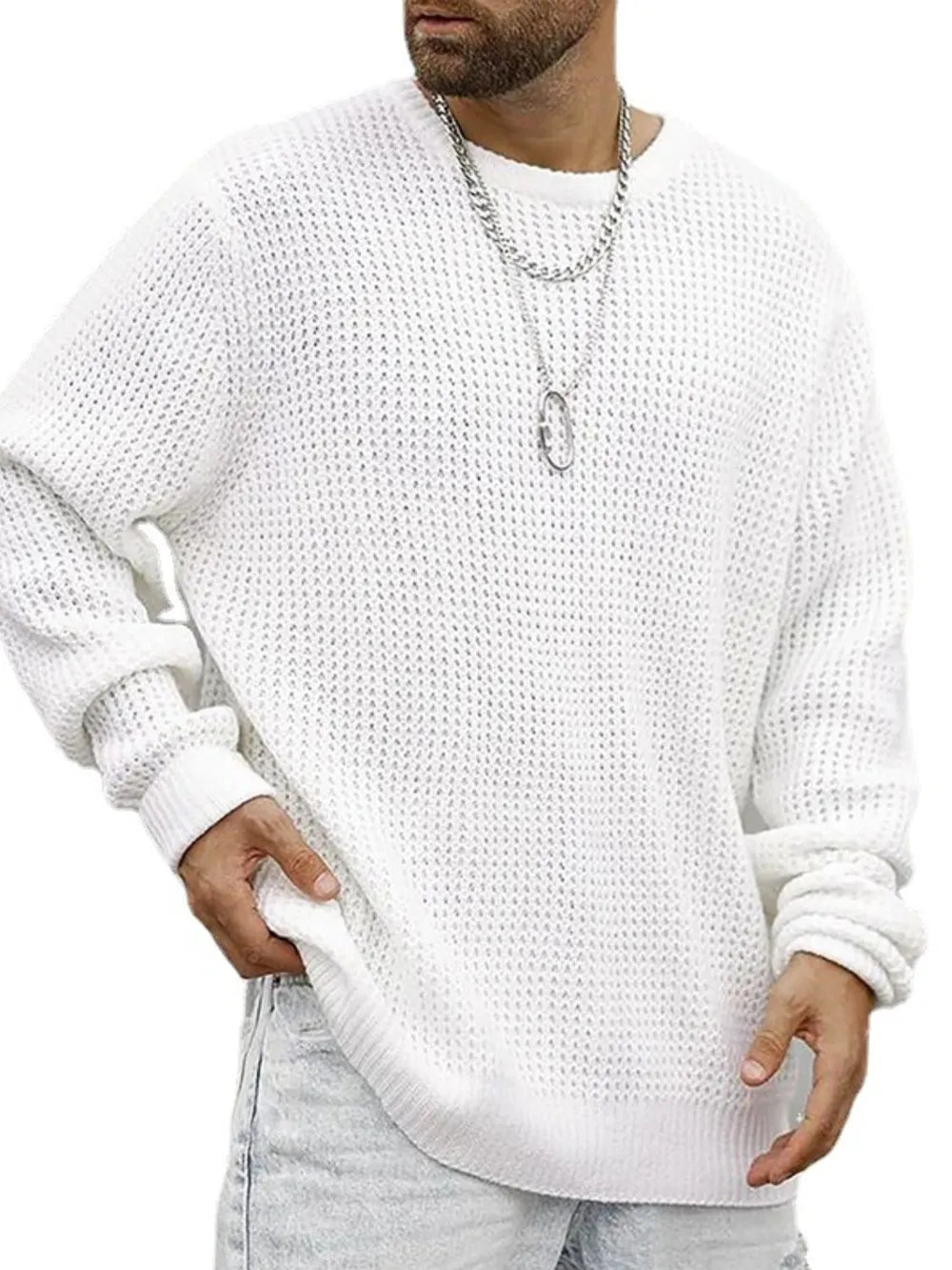 Person wearing a white textured sweater and light gray pants on a white background