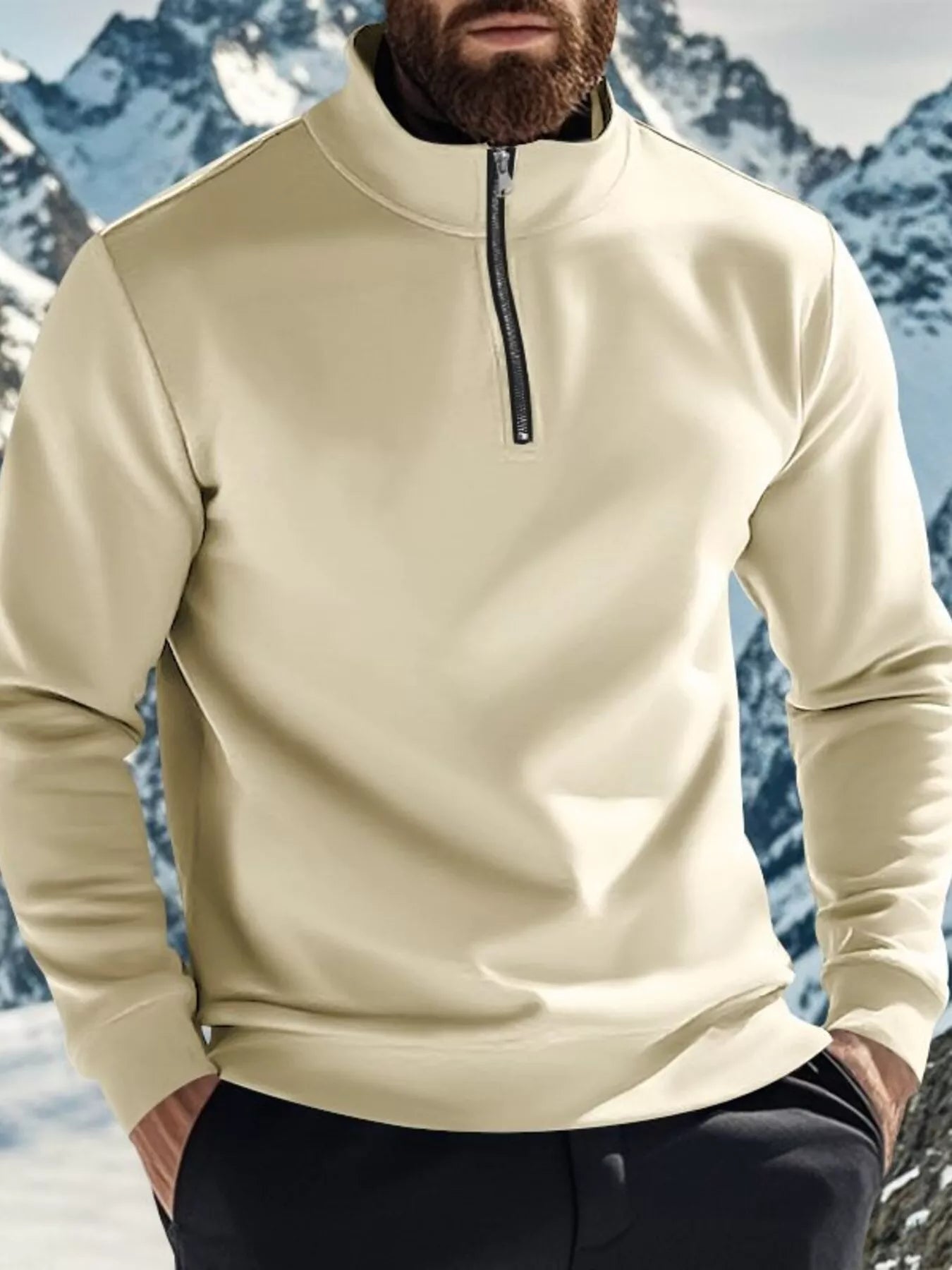 Person wearing a beige pullover with a mountainous background