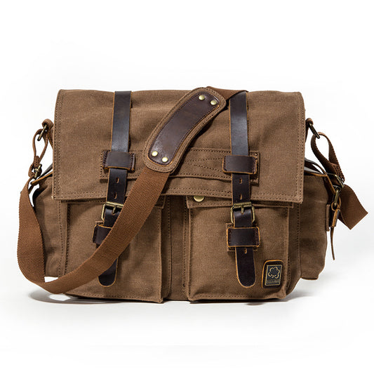 Brown canvas messenger bag with leather straps on a white background