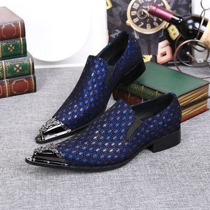 Blue and black patterned shoes with decorative toes on a textured surface.