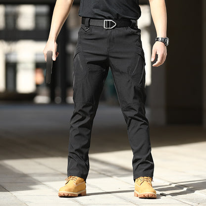 Person wearing black tactical pants with yellow shoes on a blurred street background