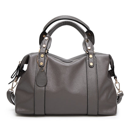 Gray handbag with gold accents on a white background