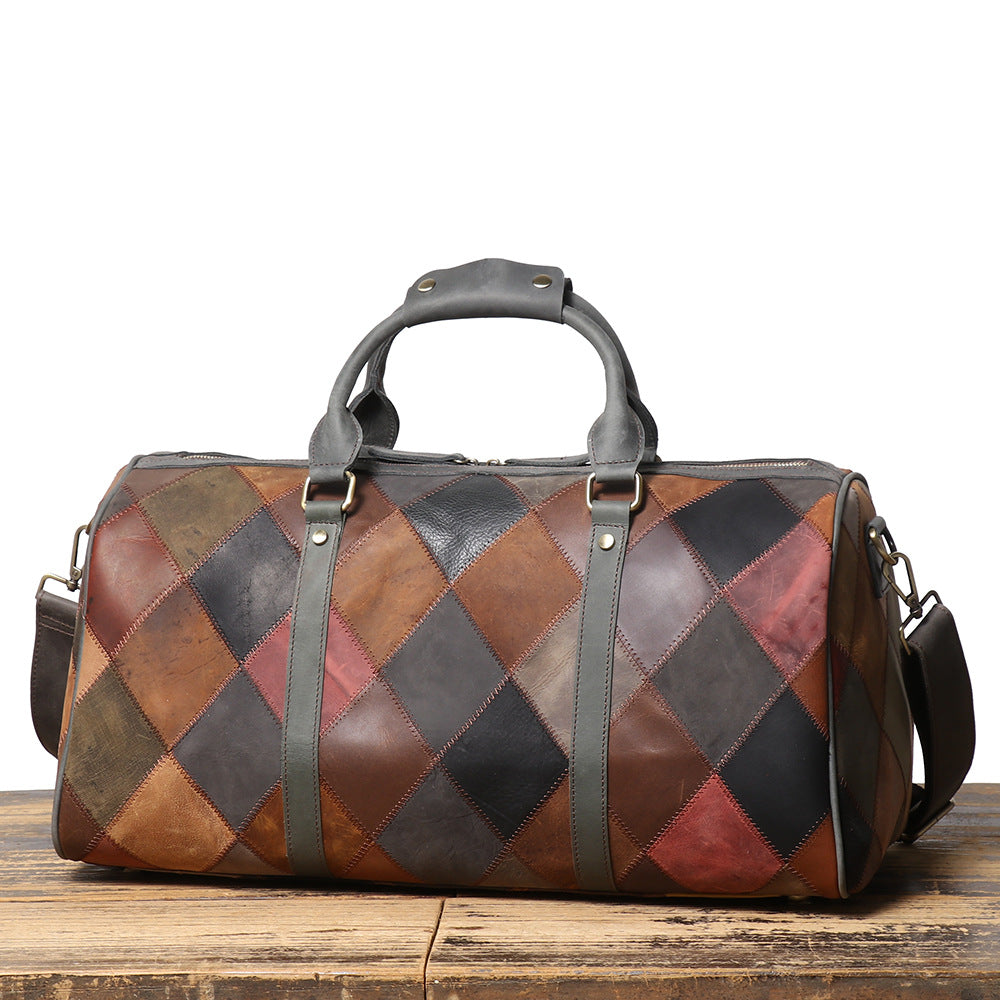 Patchwork leather duffel bag on a wooden surface with a white background