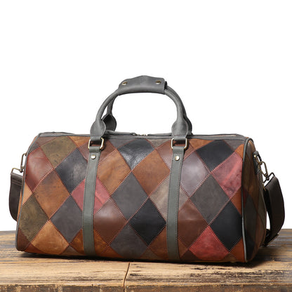 Patchwork leather duffel bag on a wooden surface with a white background