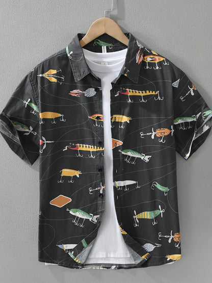 Black shirt with colorful fishing lure pattern on a hanger against a gray background