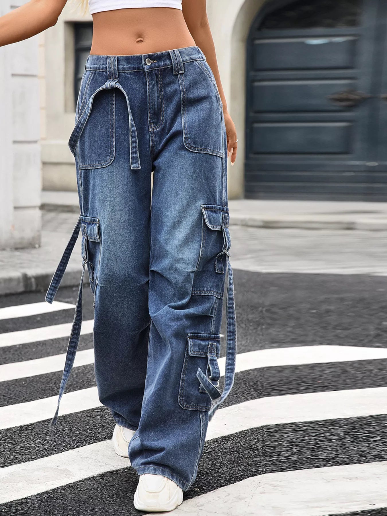 Person wearing blue cargo pants on a street with a blurred background