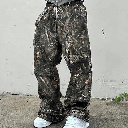 Person wearing camouflage pants with a white wall in the background.