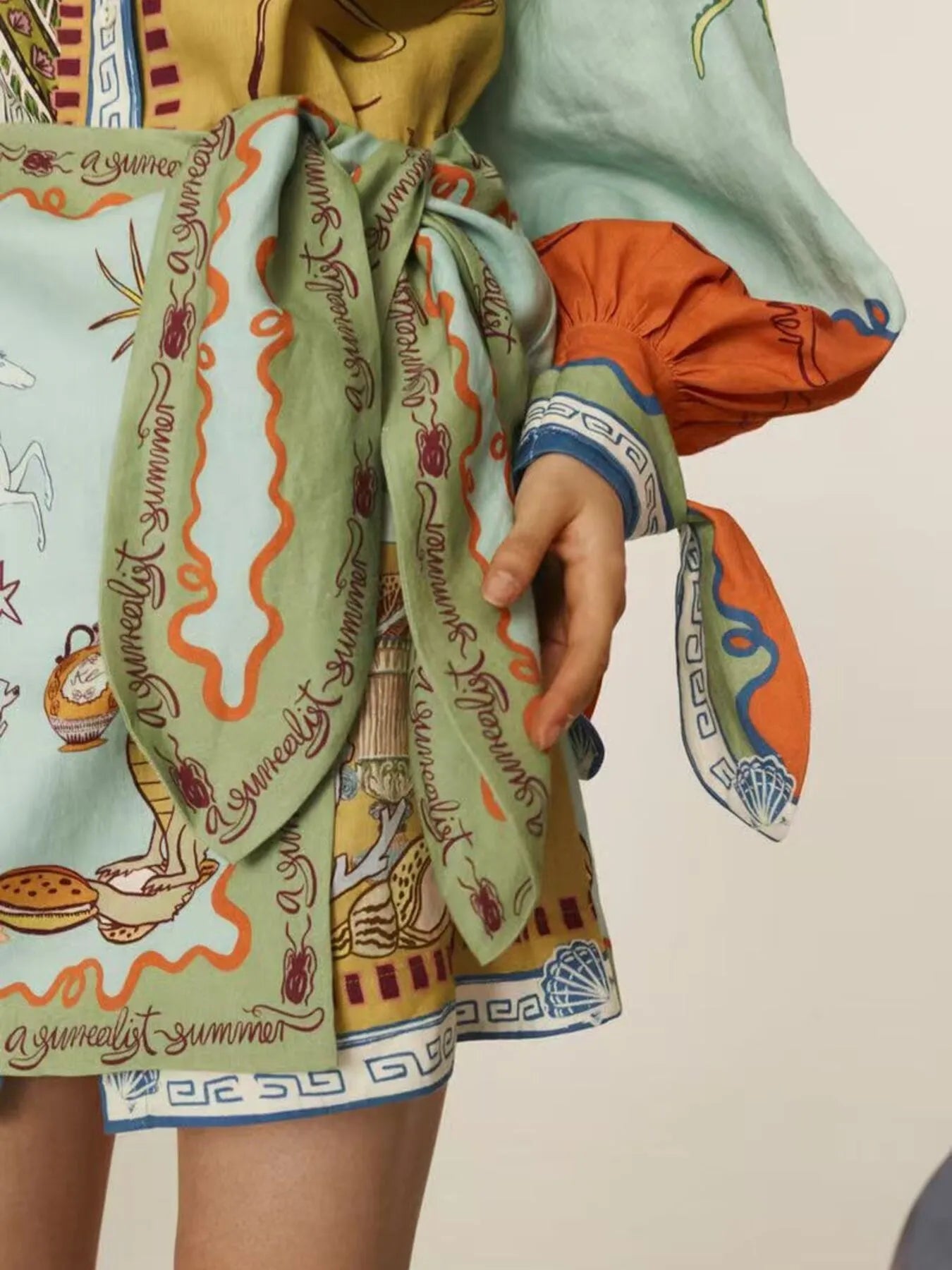 Person wearing a colorful material with artistic designs and text.