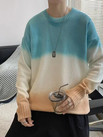 Person wearing a gradient sweater holding a clear cup with a straw.