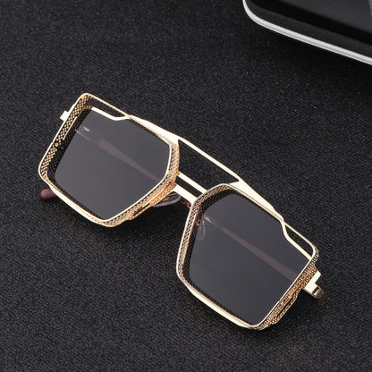 Gold-framed sunglasses with dark lenses on a black textured surface