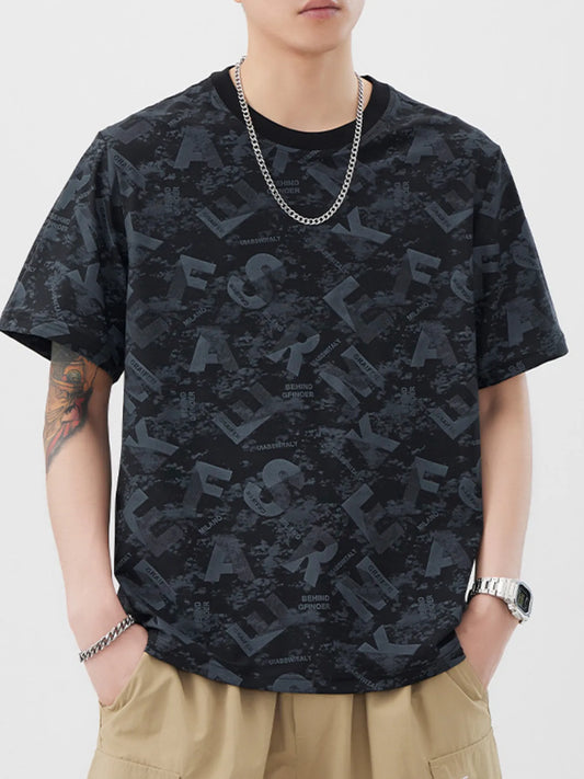 Person wearing a black patterned t-shirt and beige pants on a white background