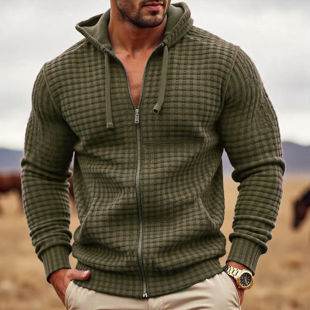 Man wearing a green textured hoodie with a blurred natural background