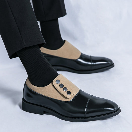 Black and beige dress shoes worn with black pants on a white background