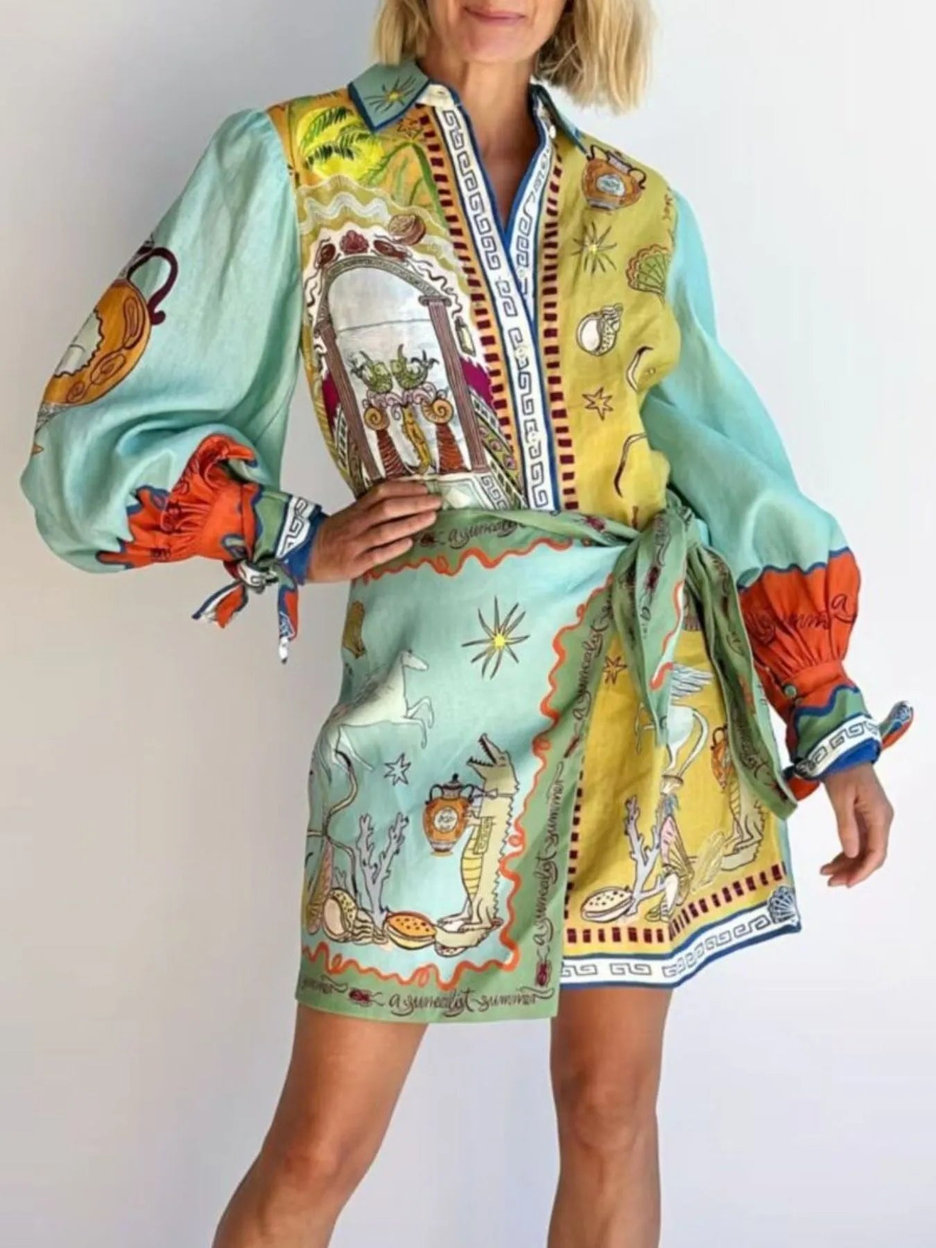 Colorful patterned dress with long sleeves and a belt on a plain background