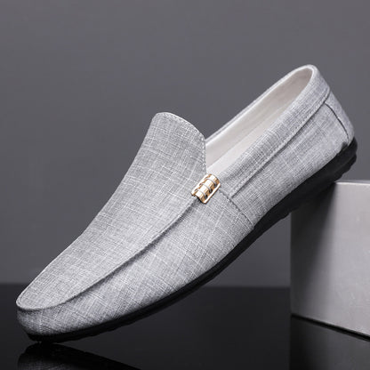 Gray loafers with a gold buckle on a dark background