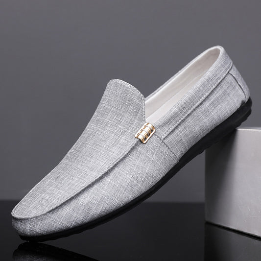 Gray loafers with a gold buckle on a dark background