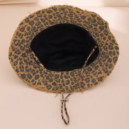 Leopard print hat with a black interior on a beige background
