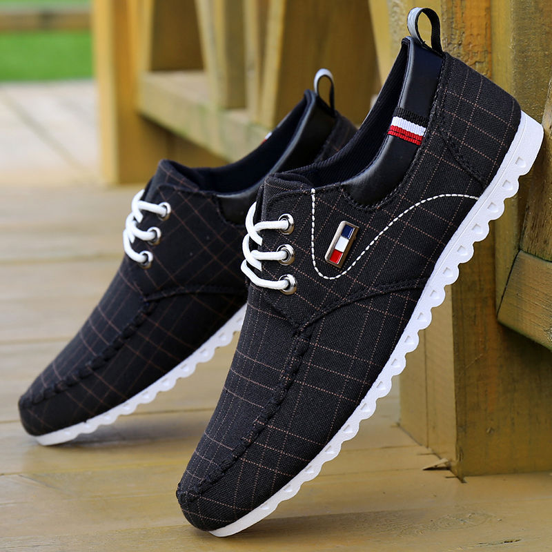 Black plaid shoes with white soles on a wooden floor