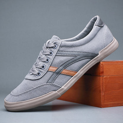 Gray sneaker with a brown accent on a wooden block against a gray background