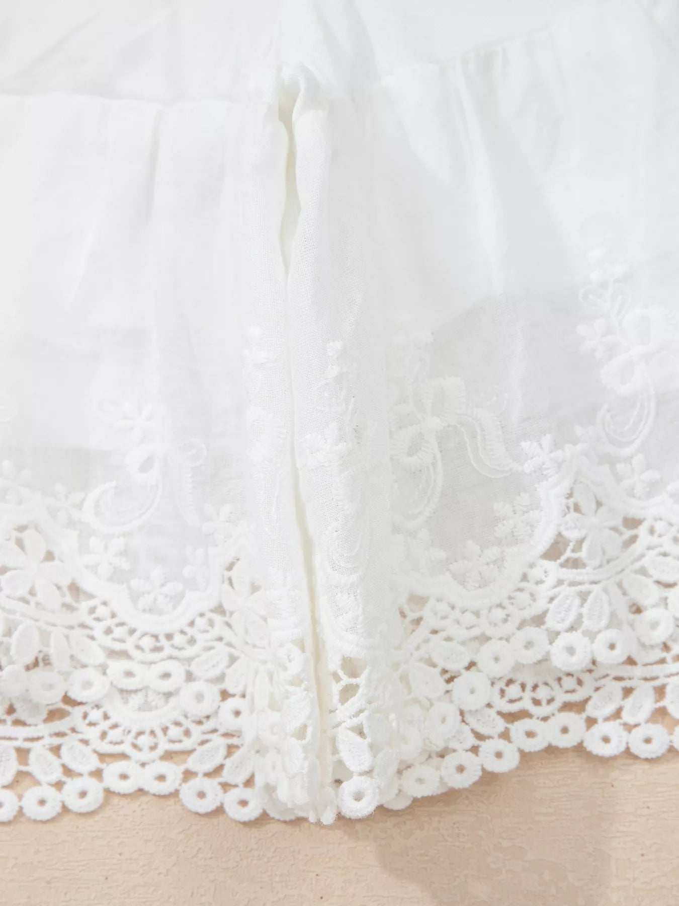 Close-up of a white lace garment on a neutral background