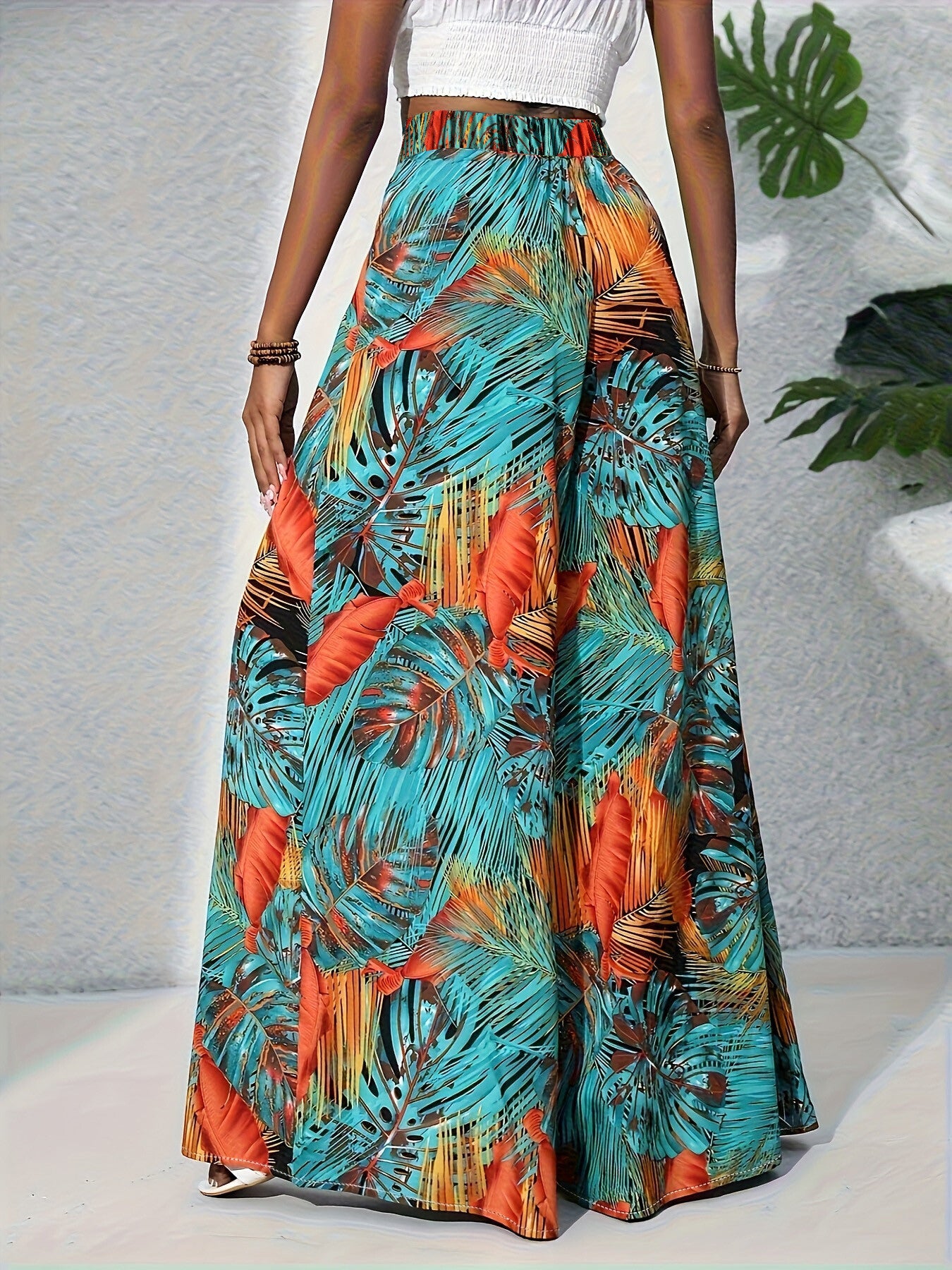 Colorful tropical leaf patterned skirt worn by a person on a neutral background